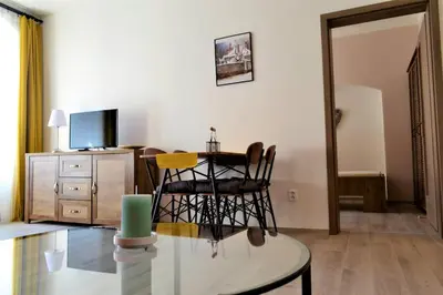 a living room with a table and chairs and a television at Pension Kotva in Beroun