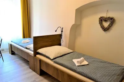 two beds in a room with a heart decoration on the wall at Pension Kotva in Beroun