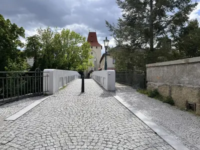 a stone walkway with a fence and a building at Pension Kotva in Beroun