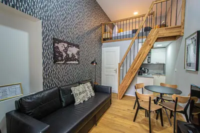 a living room with a black leather couch and a table at Main train station apartment close to the the Main Square! in Prague