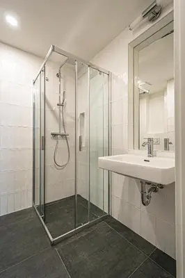 a bathroom with a glass shower and a sink at Main train station apartment close to the the Main Square! in Prague