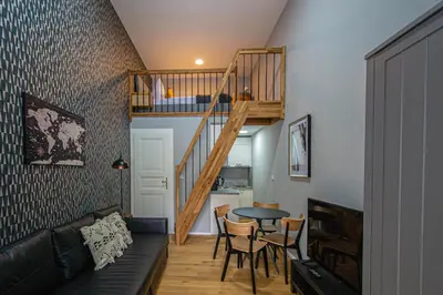a living room with a staircase and a table and chairs at Main train station apartment close to the the Main Square! in Prague