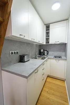a kitchen with white cabinets and a sink at Main train station apartment close to the the Main Square! in Prague