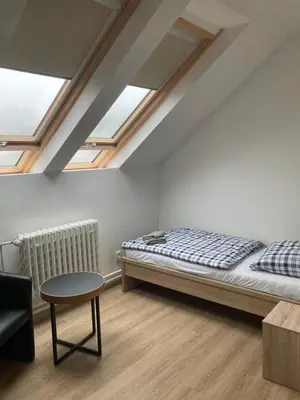 a bedroom with a bed and a table and skylights at Ubytování Na špejcharu, Želevčice in Slaný