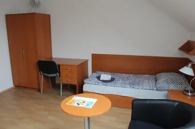 a bedroom with a bed and a table and a desk at Ubytování Na špejcharu, Želevčice in Slaný