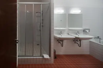 a bathroom with two sinks and a shower at AXA Hotel in Prague