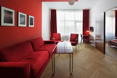 a living room with a red couch and a table at AXA Hotel in Prague