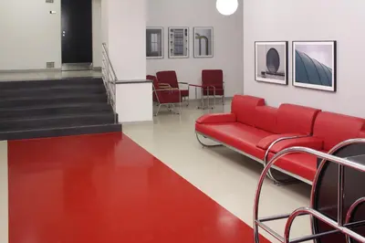 a waiting room with a red couch and chairs at AXA Hotel in Prague