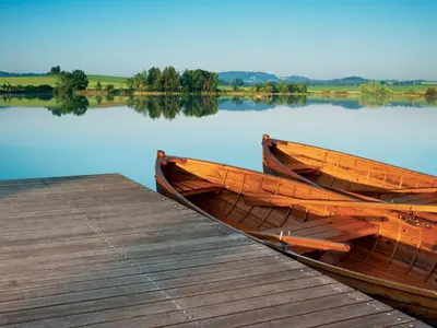 two wooden boats are docked next to a dock at Resort Čapí Hnízdo in Olbramovice Ves