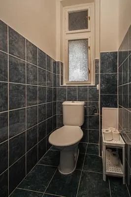 a bathroom with a toilet and a window at Super Central Billiard and Darts Big Apartment in Prague