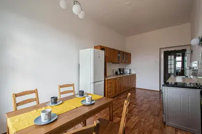 a kitchen with a table and a white refrigerator at Super Central Billiard and Darts Big Apartment in Prague