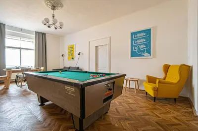 a living room with a pool table and a yellow chair at Super Central Billiard and Darts Big Apartment in Prague