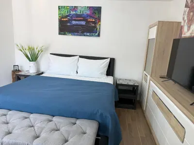 a bedroom with a blue bed and a tv at Apartment IRON CUBE in Prague
