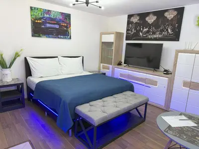 a bedroom with a blue bed and a tv at Apartment IRON CUBE in Prague