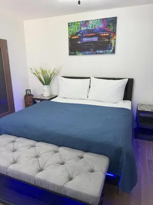 a bedroom with a bed with a blue blanket and a couch at Apartment IRON CUBE in Prague