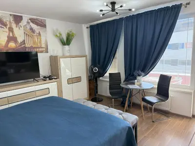 a bedroom with a blue bed and a table with chairs at Apartment IRON CUBE in Prague