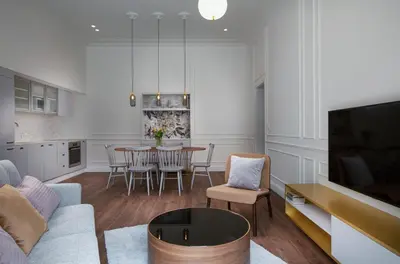 a kitchen with white cabinets and a table and chairs at OREA Place Seno in Prague