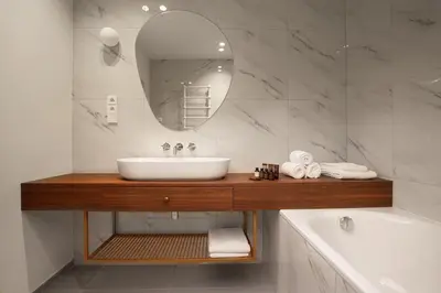 a bedroom with a bed and a table and a sink at OREA Place Seno in Prague