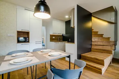 a dining room and living room with a table and chairs at Prague Days - Premium Loft with AC & View of the Žižkov Tower from Spacious Terrace in Prague