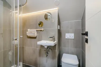 a large white door in a room with a table at Prague Days - Premium Loft with AC & View of the Žižkov Tower from Spacious Terrace in Prague