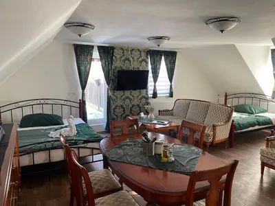 a living room with two beds and a table and chairs at Ubytování U Synagogy Dobříš in Dobříš