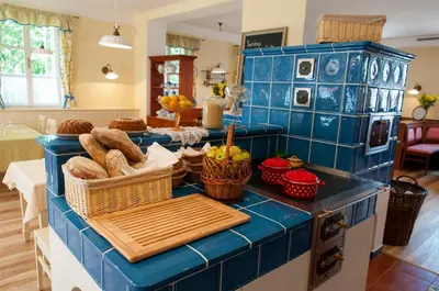 a blue tiled kitchen counter with baskets of bread at Babiččina Zahrada Penzion & Restaurant in Pruhonice