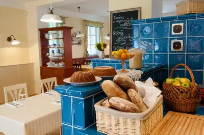 a blue kitchen with a table with baskets of bread at Babiččina Zahrada Penzion & Restaurant in Pruhonice