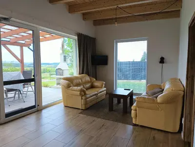 a living room with two chairs and a sliding glass door at Panorama house Brdy in Příbram