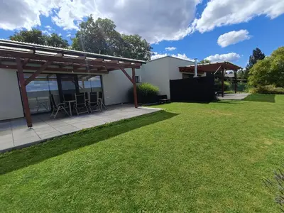 a patio with a table and chairs in a yard at Panorama house Brdy in Příbram
