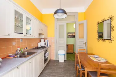 a kitchen with yellow walls and a wooden table at Andrews Centre Apartment in Prague