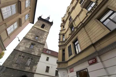 a tall building with a clock tower next to buildings at Andrews Centre Apartment in Prague
