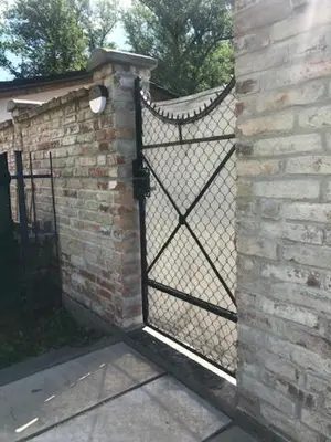 an iron gate on a brick building with a brick wall at Apartman Romantica in Poděbrady