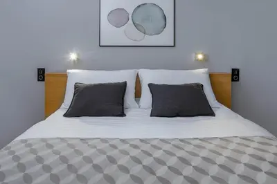 a bed with white sheets and pillows in a bedroom at Blue Orange Resort in Prague