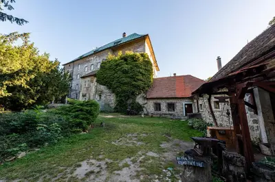 an old building with a yard in front of it at Hájovna hradu Houska in Doksy