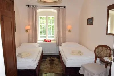 two beds in a room with a window at Hájovna hradu Houska in Doksy