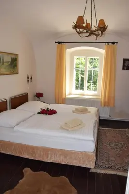 a bedroom with a large bed with a window at Hájovna hradu Houska in Doksy