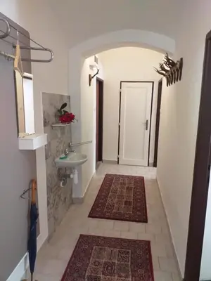 a hallway with a bathroom with a sink and a mirror at Hájovna hradu Houska in Doksy