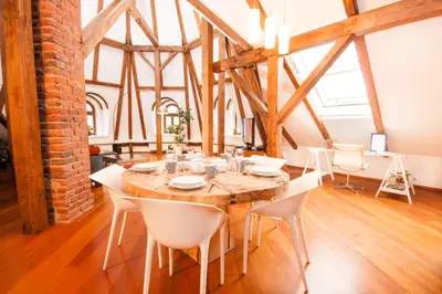 a dining room with a wooden table and white chairs at Luxury Loft in Prague
