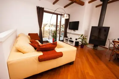 a living room with a white couch and a tv at Luxury Loft in Prague