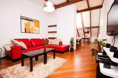 a living room with a red couch and a table at Luxury Loft in Prague