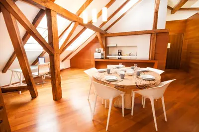 a dining room with a wooden table and white chairs at Luxury Loft in Prague