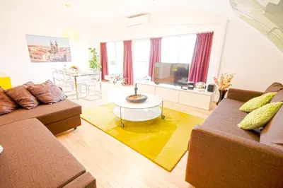 a living room with two couches and a table at Wenceslas Square Lofts in Prague