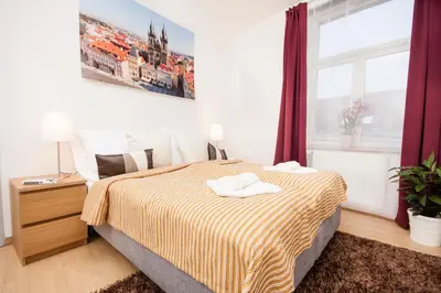 a bedroom with a bed and a large window at Wenceslas Square Lofts in Prague