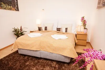 a bedroom with a large bed with two towels on it at Wenceslas Square Lofts in Prague
