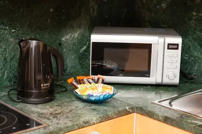 a microwave sitting on a counter next to a bowl of utensils at Wenceslas Square Lofts in Prague