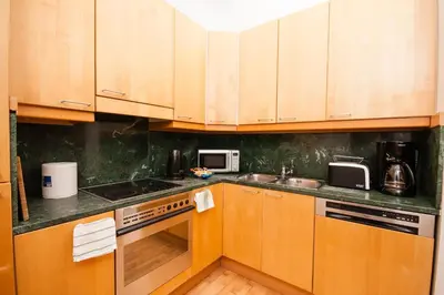 a kitchen with wooden cabinets and a counter top at Wenceslas Square Lofts in Prague