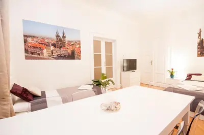 a white living room with a couch and a table at Fashion Loft in Prague