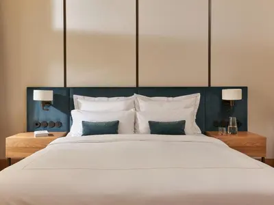 a bedroom with a large white bed with two lamps at The Julius Prague in Prague