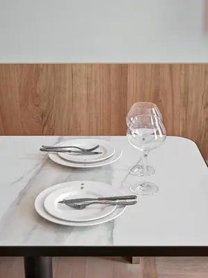 a table with two plates and a wine glass at The Julius Prague in Prague