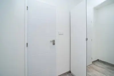 a row of white cabinets in a room at Old Town 1 Bedroom Oasis with AC and Double Shower in Prague